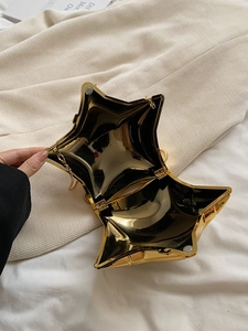 Detailed interior of gold star-shaped evening bag with metal hinge and gold chain strap