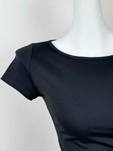 Détail de l'encolure et des manches d'un t-shirt noir ajusté avec épaules dénudées