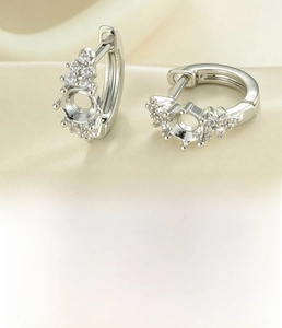 Detail of silver plated hoop earrings with 4mm empty setting and zircon stones