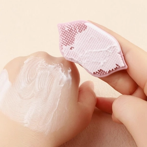 Pink silicone exfoliating lip brush with soft bristles and suction cup for facial cleansing