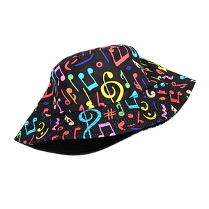 Close-up of colorful music note prints on a black reversible canvas bucket hat