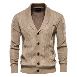 Macro view of khaki shawl collar knit cardigan showing cable knit texture and buttons