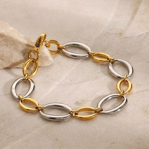 Two-tone gold and silver stainless steel chunky link bracelet on stone background