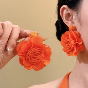 Elegant large orange chiffon flower stud earrings shown on a model for a stylish summer look