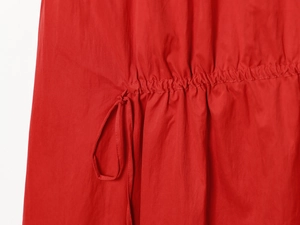 Détail d'une robe midi rouge avec cordon de serrage et taille élastique ajustable