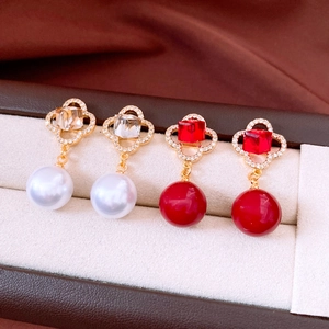 Detail of vintage flower earrings with pearl pendants and sparkling square zirconia