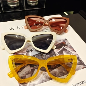 Detailed view of retro triangle cat eye sunglasses in brown, white and yellow colors