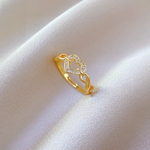Macro shot of gold heart-shaped ring with pave zircons on soft white silk fabric