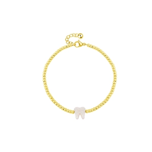 Bracciale chic in acciaio al titanio dorato con ciondolo a dente bianco su sfondo bianco