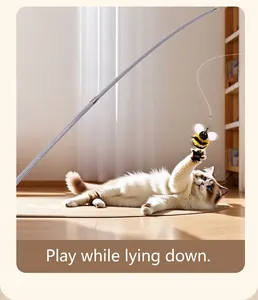 Detail showing a cat playing with the bee teaser toy on a wooden floor