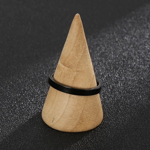 Close-up of a 3mm black stainless steel ring on a wooden cone display with black background