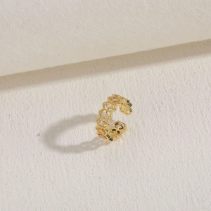 Makro-Detail des goldenen geometrischen Ear Cuffs mit Marquise-Zirkonia-Steinen