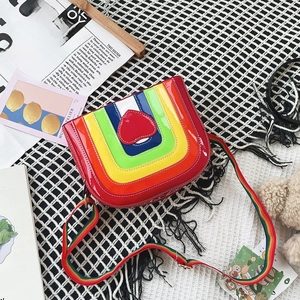 Detailed shot of rainbow striped crossbody bag with a red heart and adjustable strap