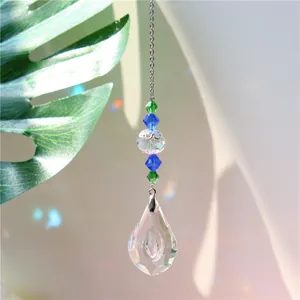 Close-up of heart crystal suncatcher with rainbow light spots and teardrop pendant