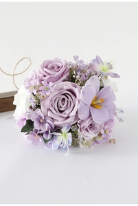 Close-up of artificial bridal bouquet with purple roses and white lilies for outdoor weddings