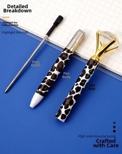 Detail of leopard print metal ballpoint pen with a large diamond top and refill