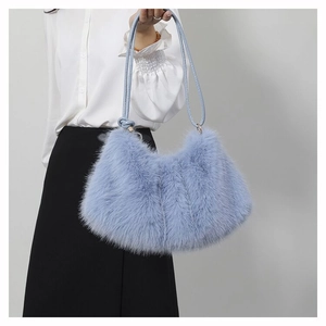 Détail du sac d'épaule en fausse fourrure bleu clair avec poignée en cuir et métal doré