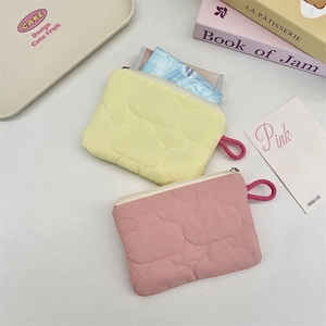 Detailed view of quilted cloud coin pouches in soft yellow and pale pink colors