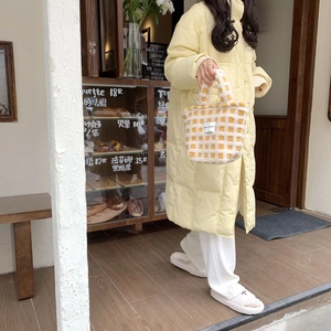 Chic checkered faux fur tote bag styled with a yellow quilted winter puffer coat