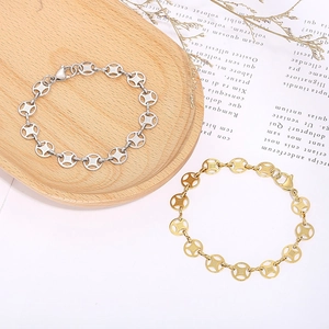 Gold and silver ancient coin style bracelets on wooden tray and decorative vintage book pages
