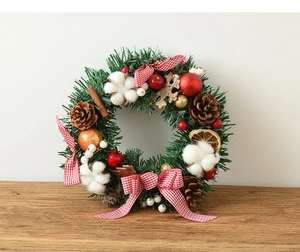 Detailed view of Christmas wreath with pine cones cotton balls and red checkered bow