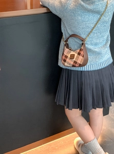 Détail du sac bandoulière enfant à carreaux avec chaîne dorée et cuir marron