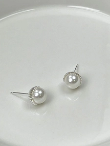 Detailed macro view of elegant round white pearls on a silver metal stud base