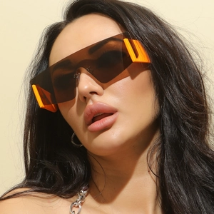 Oversized rimless wrap-around sunglasses with brown lenses and orange side frames for fashion