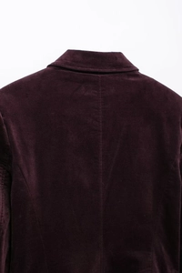 Détail du col et des coutures d'épaule de la veste en velours violet foncé sur tissu