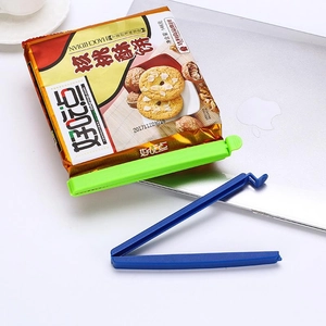 Plastic food bag sealing clips for snacks shown in blue and green on a white desk