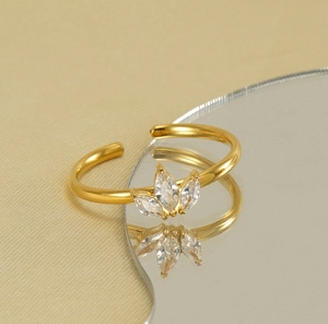 Détail macro de la bague feuille d'érable dorée avec zircons sur fond de soie