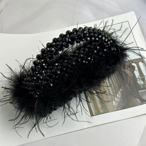 Detail of luxury evening bag with black ostrich feathers and polished handmade beads