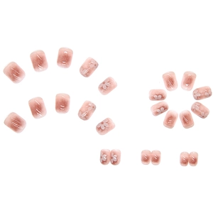 Pink gradient press-on nails with white cherry blossom patterns and glossy resin finish