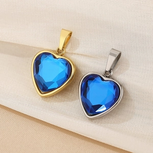 Makroaufnahme von 18K Gold- und Silber-Herzanhängern mit blauen Zirkonia-Steinen