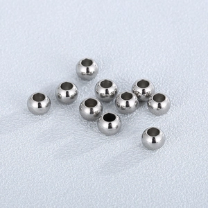 Vista macro di perle in acciaio inossidabile lucido argento per creazione gioielli DIY