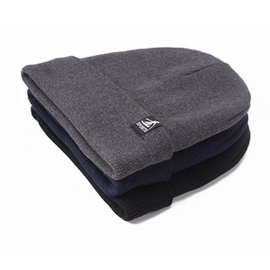 Close-up of knit beanies in dark gray, navy, and black with sports tags for winter