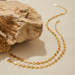 Golden titanium steel necklace with colorful flower charms over natural stone