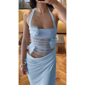 Détail de fleurs 3D avec perles et résille transparente sur une robe bleu clair