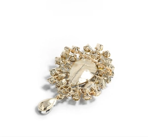 Macro shot of luxury crystal brooch back with gold metal texture and drop pendant