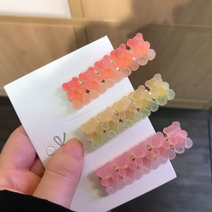 Three gradient gummy bear hair clips with sugary matte resin texture on golden clips