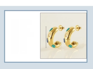 Détail de boucles d'oreilles C en titane plaqué or 18K avec turquoise et œil de chat