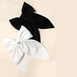 Close-up of black and white large fabric bow hair clips with long ribbon tails set of 2