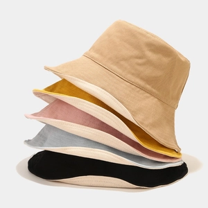 Detail of stacked cotton bucket hats in khaki, yellow, pink, blue, and black with fine stitching