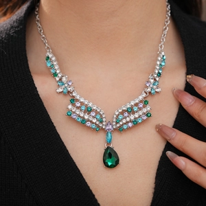 Close-up of vintage jewelry set featuring a silver necklace with colorful crystal pendant