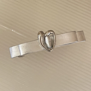 Dettaglio della clip per capelli argento opaco con design a cuore centrale cavo