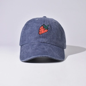 Primo piano di un cappellino da baseball blu slavato con ricamo a fragola.