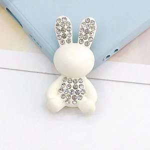 Vista macro di un ciondolo a forma di coniglio bianco con strass per cover cellulari