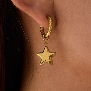 Macro view of gold hammered hoop earring with star pendant and pearl detail