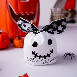 Dettaglio di sacchetti regalo di Halloween bianchi con orecchie a stelle e visi di fantasmi