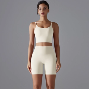 Dettaglio dei pantaloncini da yoga a vita alta e del reggiseno sportivo crema